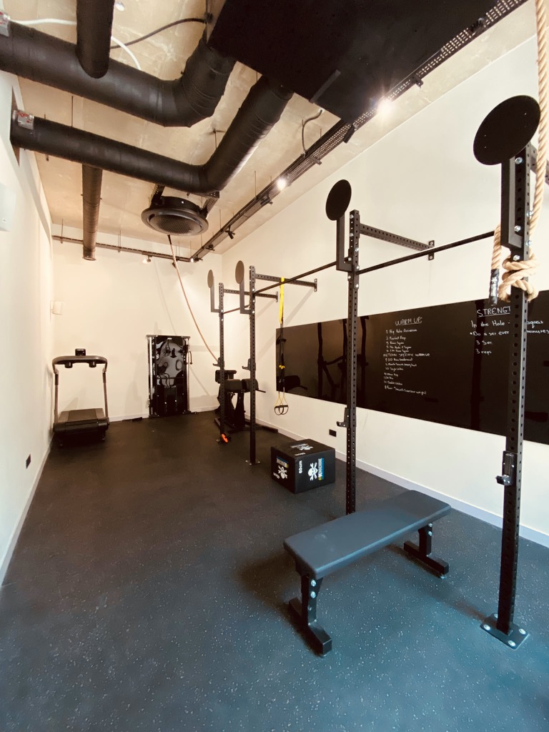 Avalon Gardens gym strength area with rack, bench and training equipment