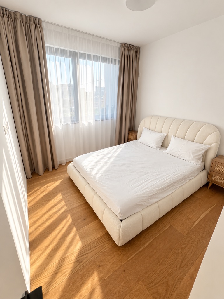 Third bedroom with cream upholstered bed and window at Harmony Residence Villa 12