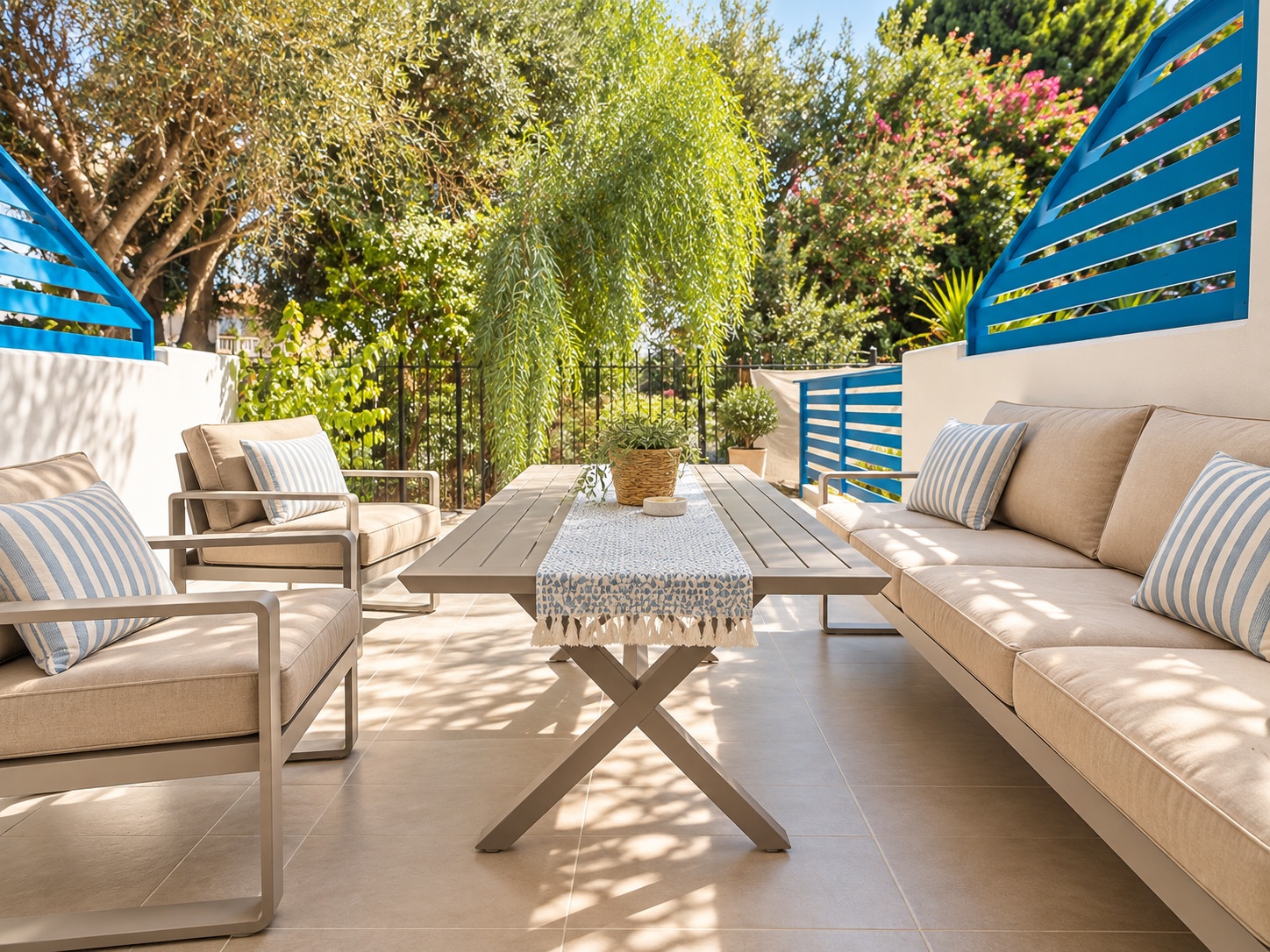 Outdoor dining table and lounge seating surrounded by greenery at Paradise Gardens Villa 30