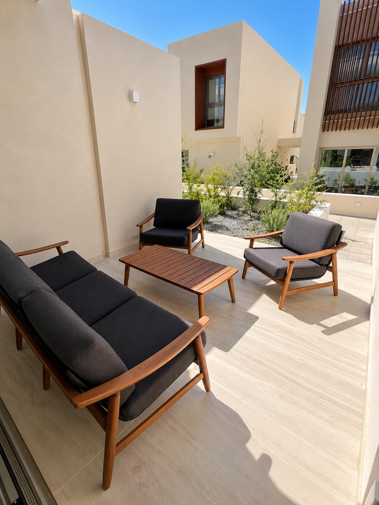 Furnished private terrace at Avalon Gardens A002 with outdoor sofa, two armchairs and wooden coffee table