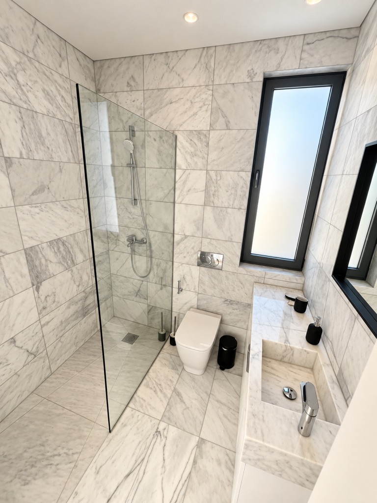 Marble bathroom with walk-in glass shower, WC and vanity at Harmony Residence Villa 12