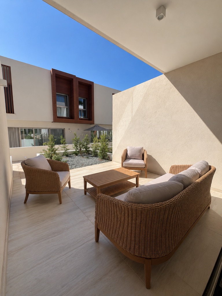 Avalon Gardens A007 covered private terrace with sofa, two armchairs and coffee table
