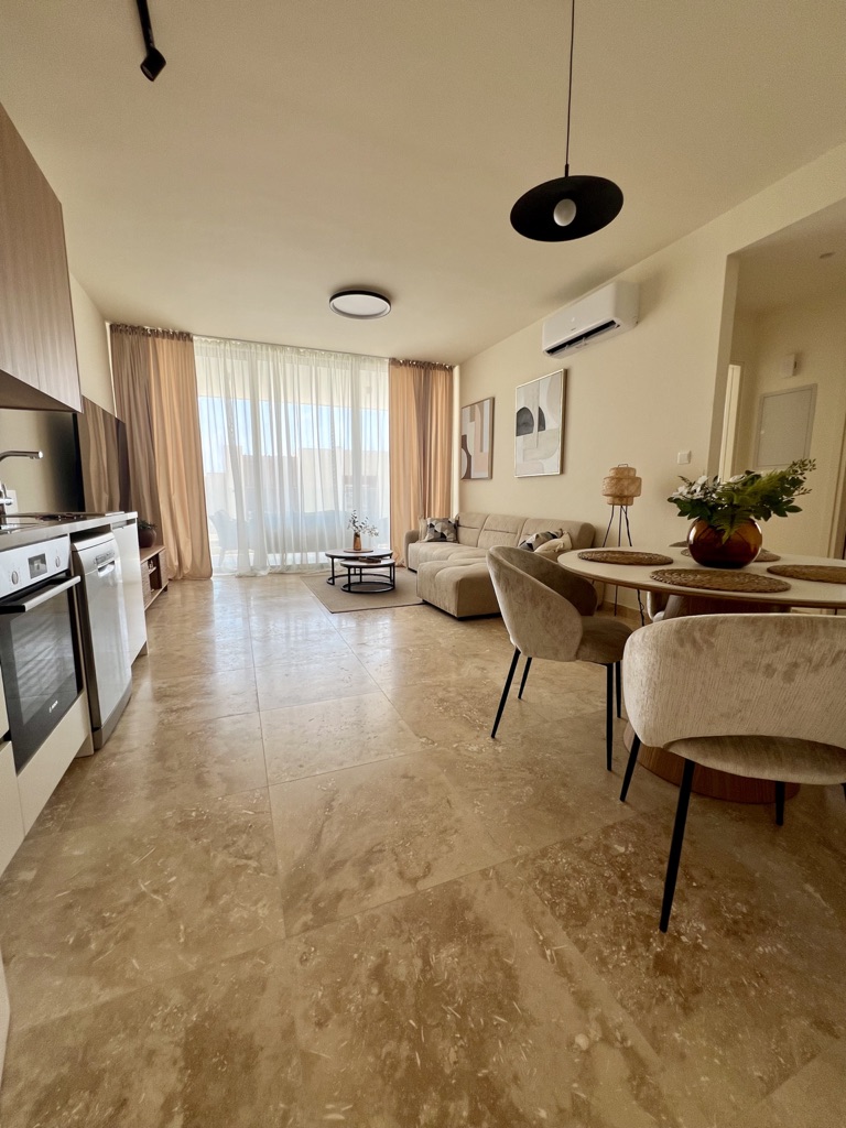 Representative open-plan living, dining and kitchen area in a serviced one-bedroom apartment at Avalon Gardens