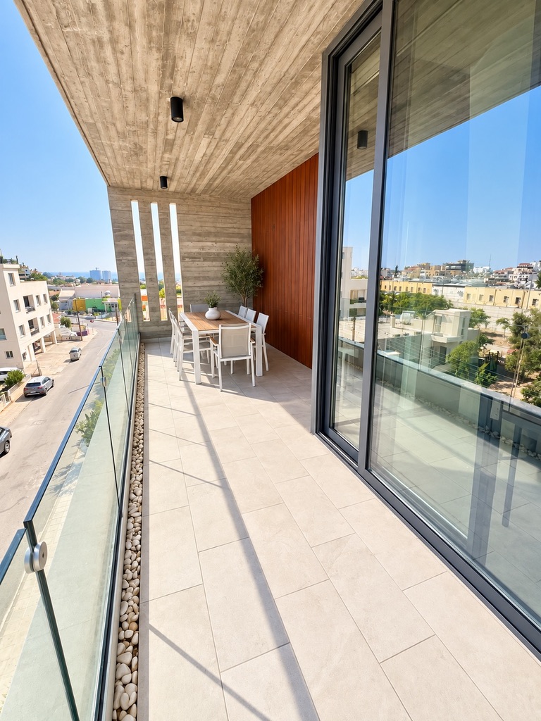 Long furnished private balcony with outdoor dining table at Stay City 301 in Agios Theodoros, Paphos
